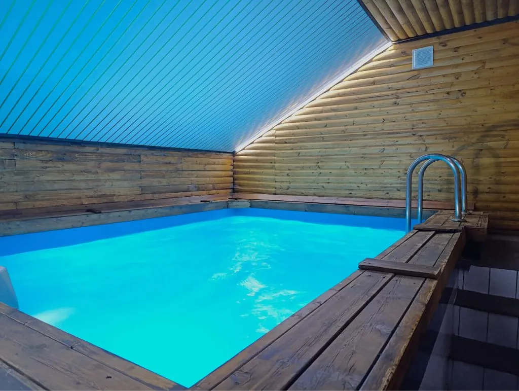 Уютный деревянный бассейн в арт-отеле VE Art Resort, Подмосковье, внутри просторного помещения с теплоизоляцией и мягким освещением для комфортного отдыха и релаксации.